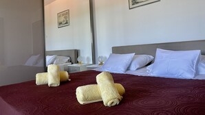 A hotel room with a large bed, two bedside tables, a nightstand, and a mirror. - Apartments Veli Rat (Sali)