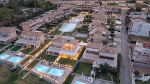A residential area with multiple houses, a swimming pool, and a well-maintained lawn. - Seafront Villa Ciel with Private Pool in Nafpaktos (Platanitis)