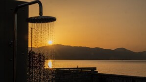 A showerhead with water flowing into a body of water during sunset. - Seafront Villa Ciel with Private Pool in Nafpaktos (Platanitis)