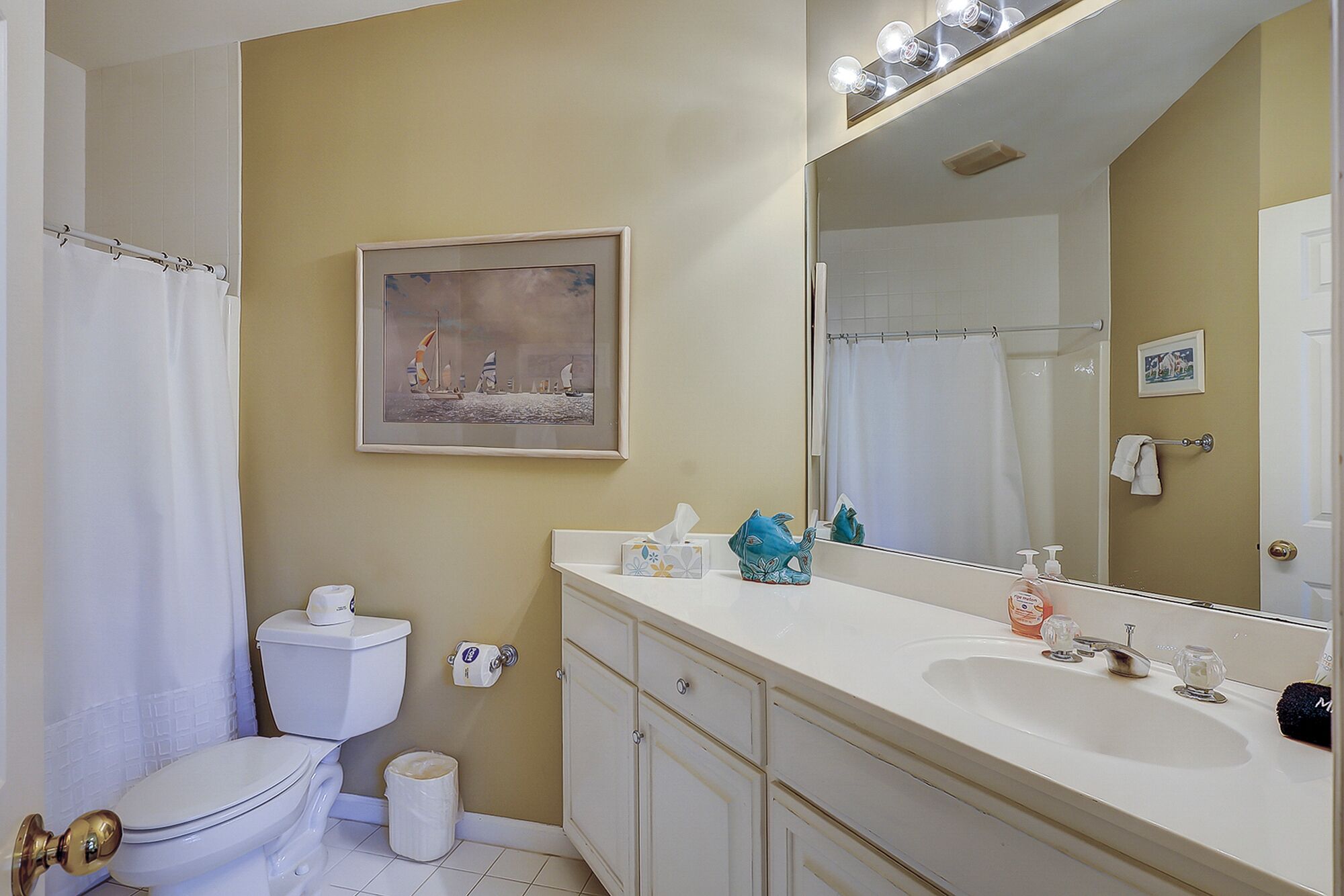 A bathroom with a toilet, sink, and mirror.