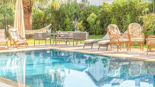 A poolside area with lounge chairs and a hammock. - Kalender Pansiyon Fethiye (Fethiye)