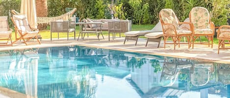 Utomhuspool, parasoller och solstolar