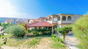 A building with multiple arches and a covered patio area. - Apartments Josip S (Lopar)