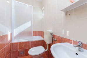 Ein Badezimmer mit Toilette, Waschbecken und Dusche.