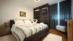 Ein modernes Schlafzimmer mit Bett, Nachttisch, Kommode, Schreibtisch und großem Kleiderschrank.
