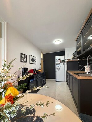 Una cocina moderna con una isla central, armarios negros y un refrigerador.