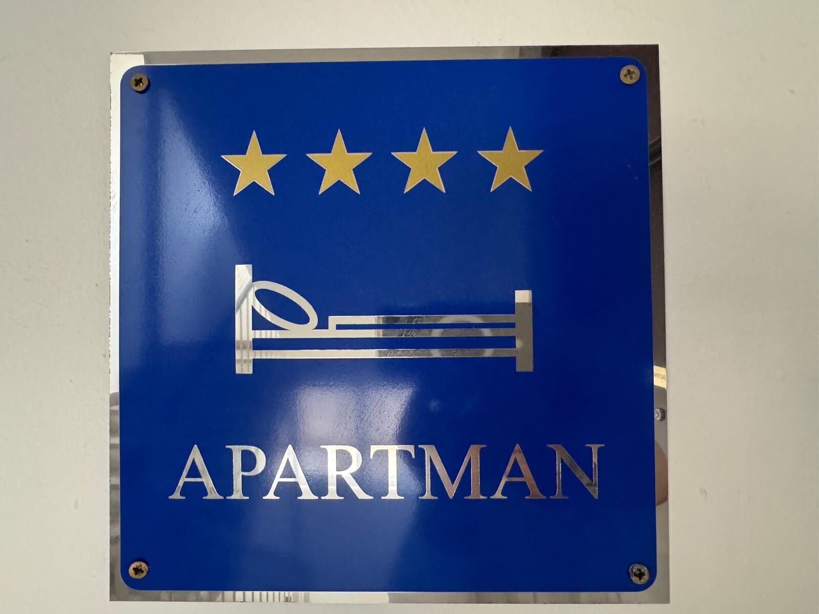 A sign with the word "APARTMAN" and a bed symbol, indicating a men's room.