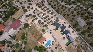 An aerial view of a residential area with multiple houses, a swimming pool, and a small park. - Mobile Home Banovi Dvori (Tisno)