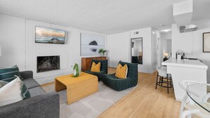 Ein modernes Wohnzimmer mit Kamin, Essbereich und Küche.