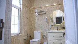 A bathroom with a toilet, sink, mirror, and towel rack. - Dionis Hotel (Baku)