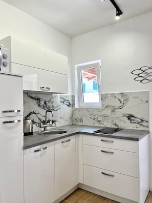Frigobar, placa de cocina, tetera/pava eléctrica, utensilios de cocina