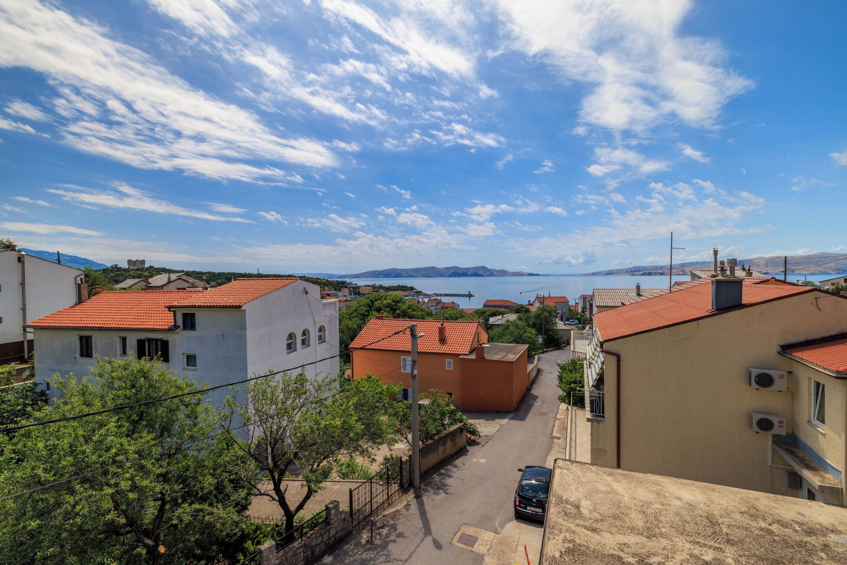Eine Küstenstadt mit Gebäuden, blauem Himmel und Blick aufs Meer.