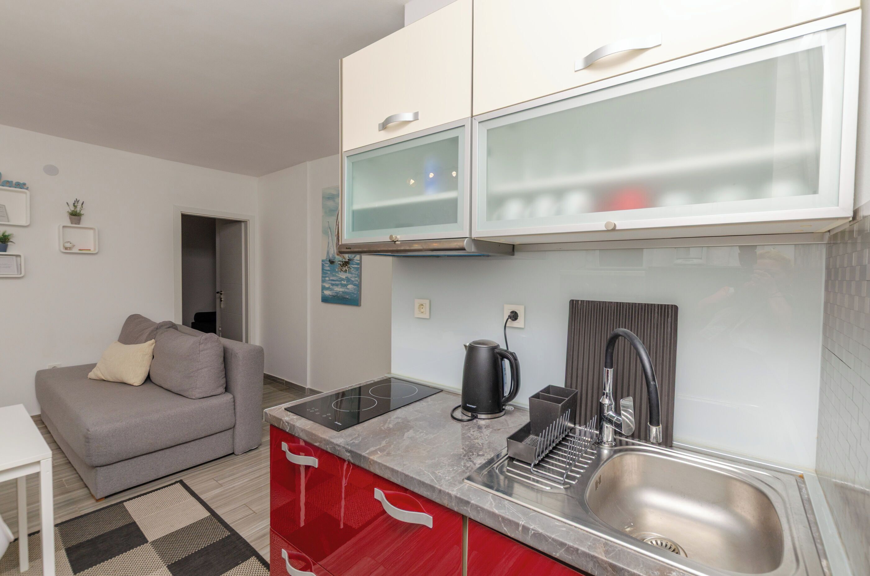 A compact kitchen with a built-in stove, a sink, and a coffee maker.