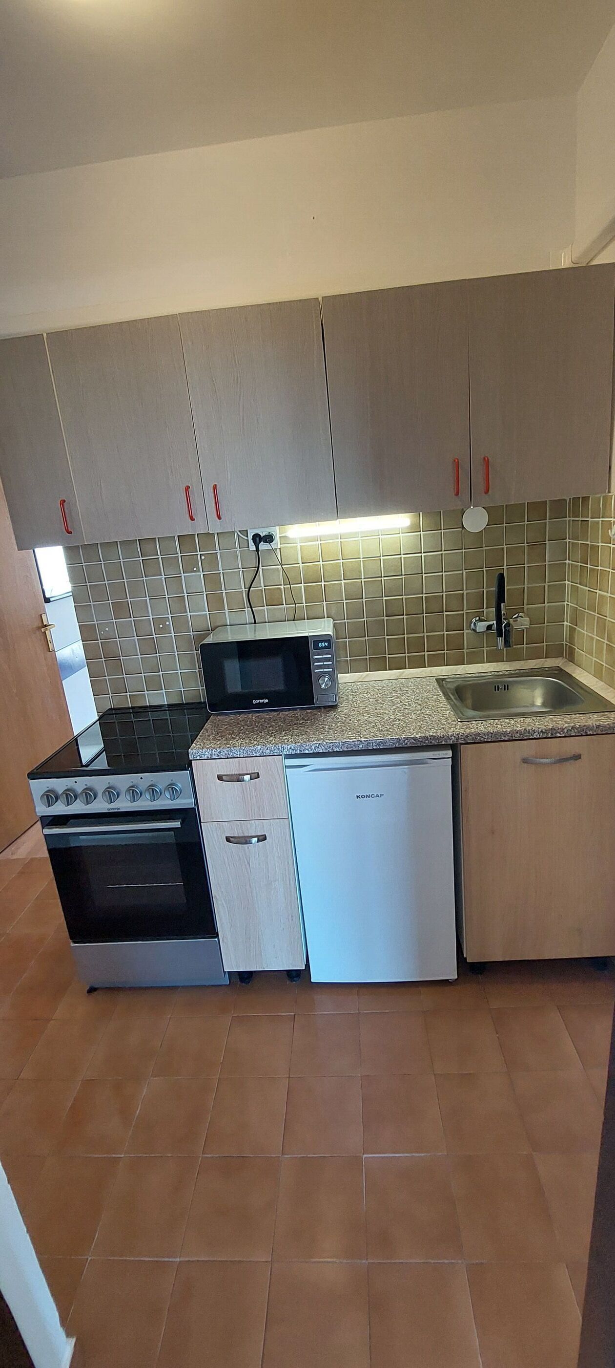 A compact kitchen with a built-in microwave, stove, and dishwasher.