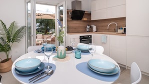 Eine moderne Küche mit weißen Schränken, einer Holz Arbeitsplatte und einem eingebauten Backofen.
