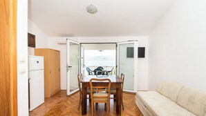 Ein kompakter Wohnbereich mit Essplatz, Küchenzeile und Sofa.