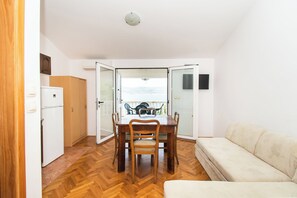 A compact living space with a dining area, kitchenette, and a sofa. - Apartments More Sunce (Starigrad)