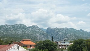 Eine gebirgige Landschaft mit Gebäuden im Vordergrund.