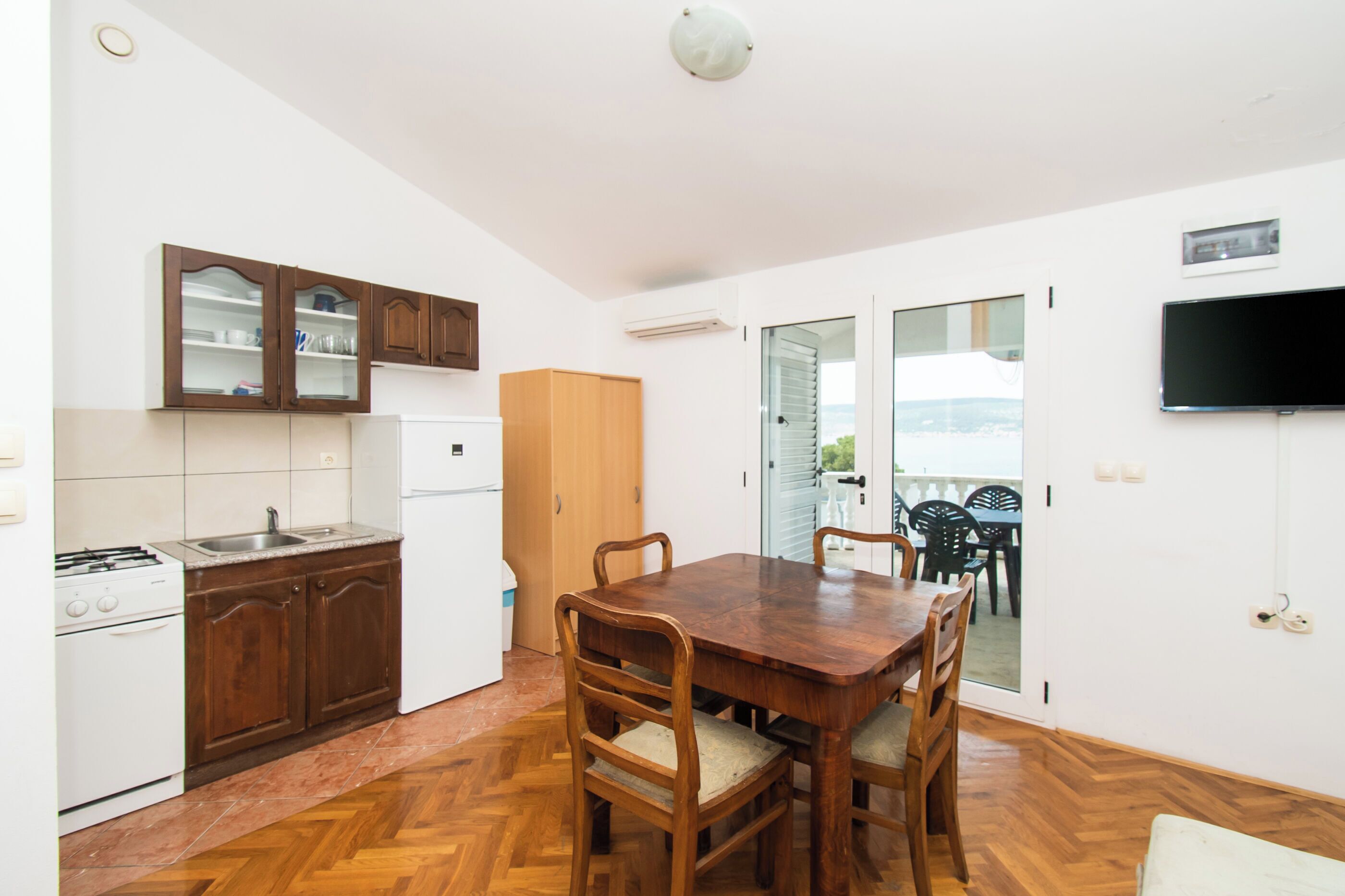 A kitchen with wooden cabinets, a stove, and a dining table with chairs.