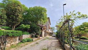 A residential street with a gravel path, stone walls, and lush greenery. - Apartment Sandra (Novi Vinodolski)