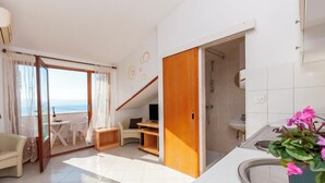 Een moderne woonkamer met balkon, eethoek en keuken.