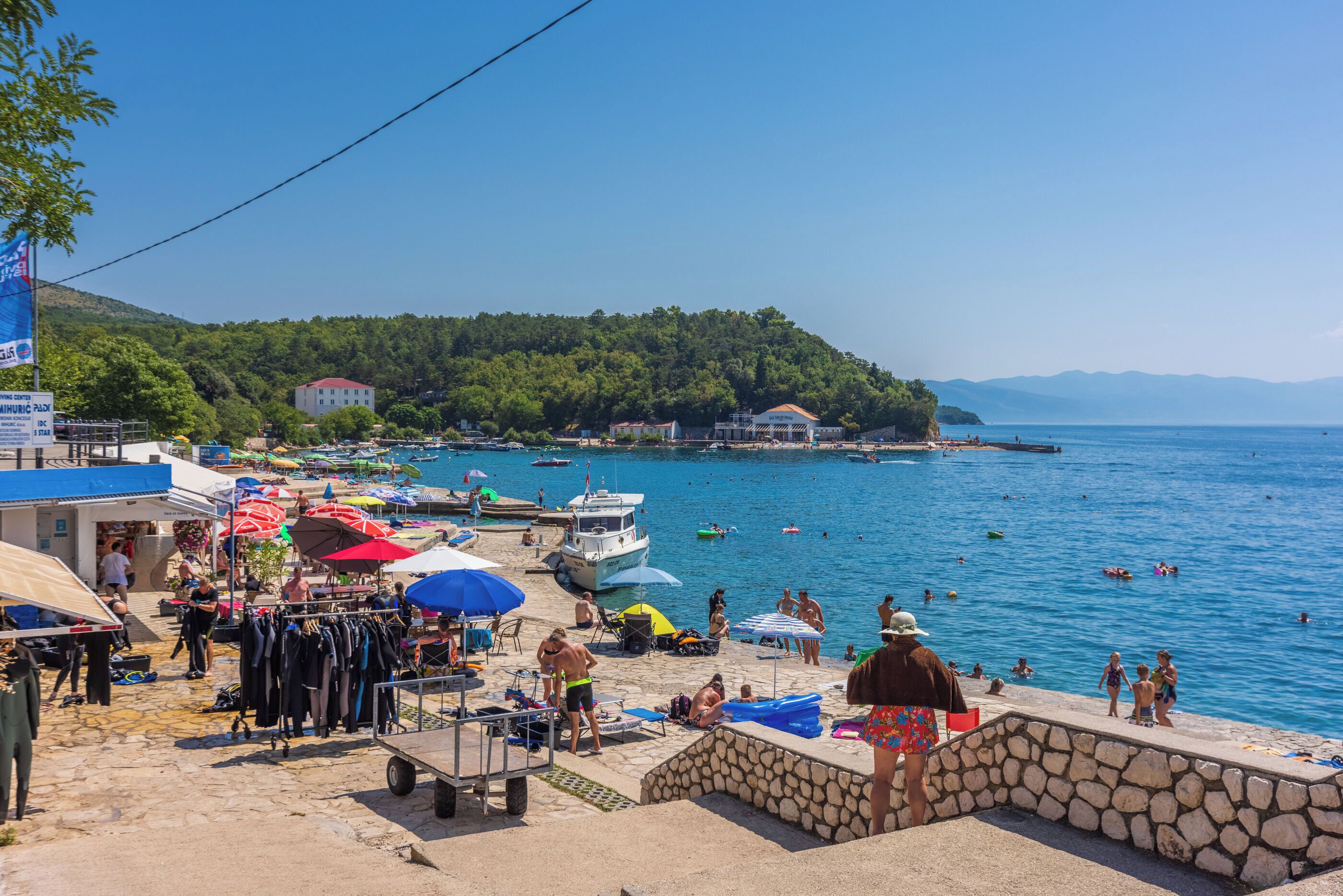 Eine Küstenlandschaft mit Strand, Booten und einer felsigen Küste.