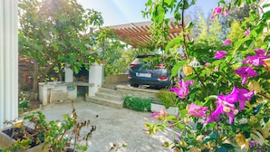 A car parked in a driveway with steps leading to a house. - Apartments Marija G (Rab)
