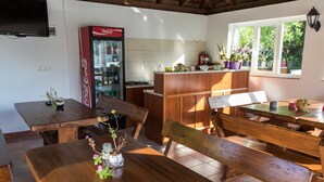 Una cucina accogliente con mobili in legno, un frigorifero Coca-Cola e una finestra con piante.