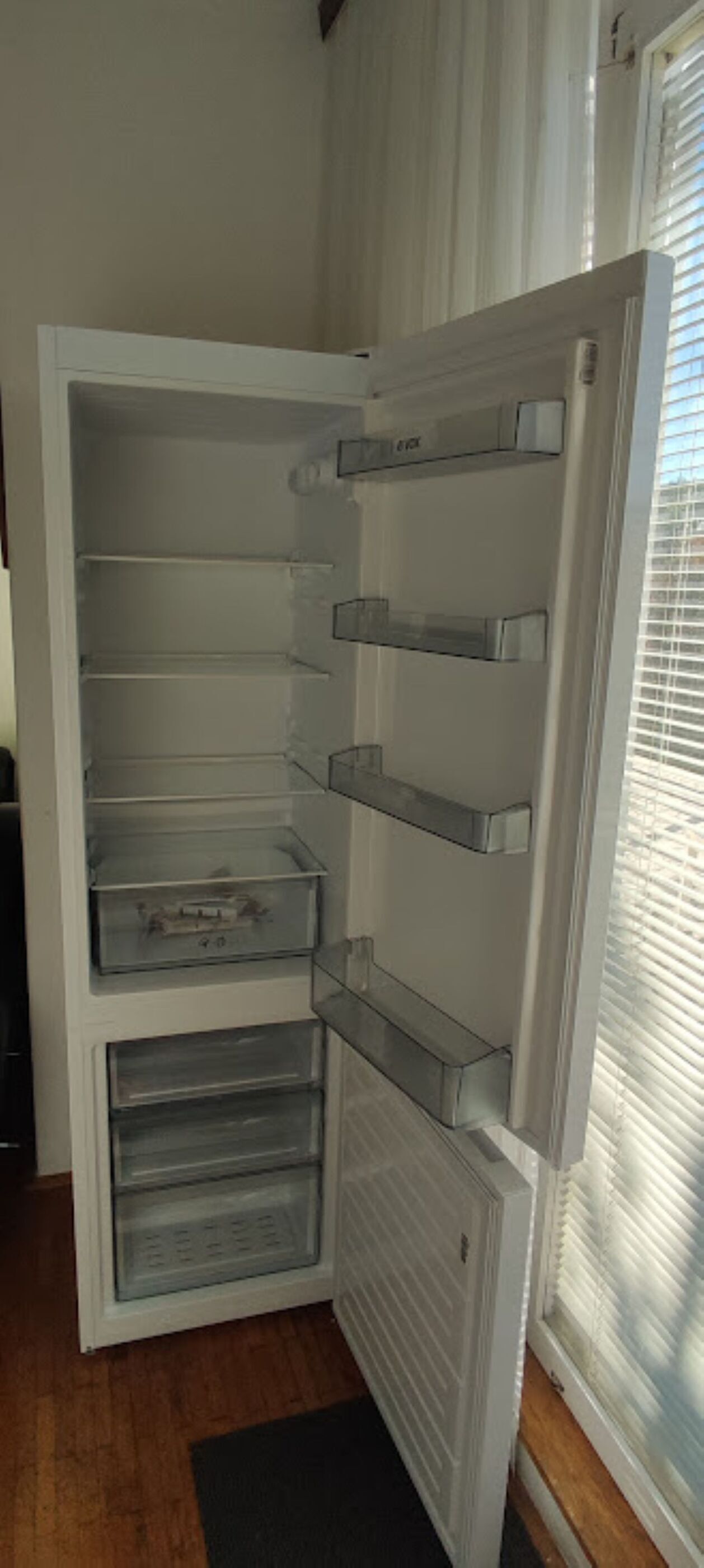 An open refrigerator with multiple shelves and a freezer compartment.