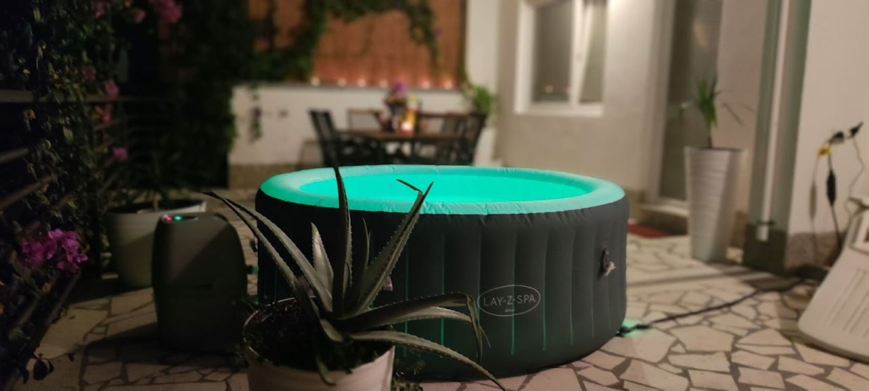 A spa-themed room with a circular seating area, a potted plant, and a small table with chairs.