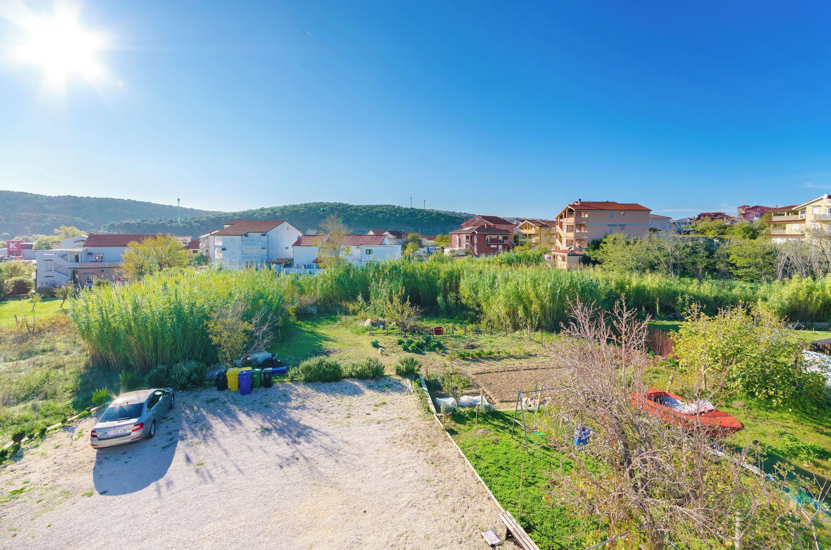 A residential area with houses, a parking lot, and a small boat.