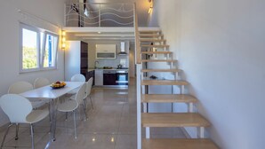 Una cocina moderna con comedor, una escalera y vistas al exterior.