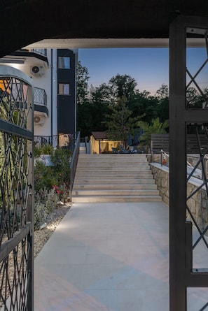 Un edificio moderno con una escalera que conduce a un espacio cubierto con asientos al aire libre.