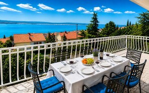 A table set for two with a view of the sea and hills. - Apartments Vukelic (Crikvenica)