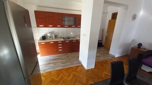 Eine moderne Küche mit Holzschränken, einem Kühlschrank und einer Kaffeemaschine.