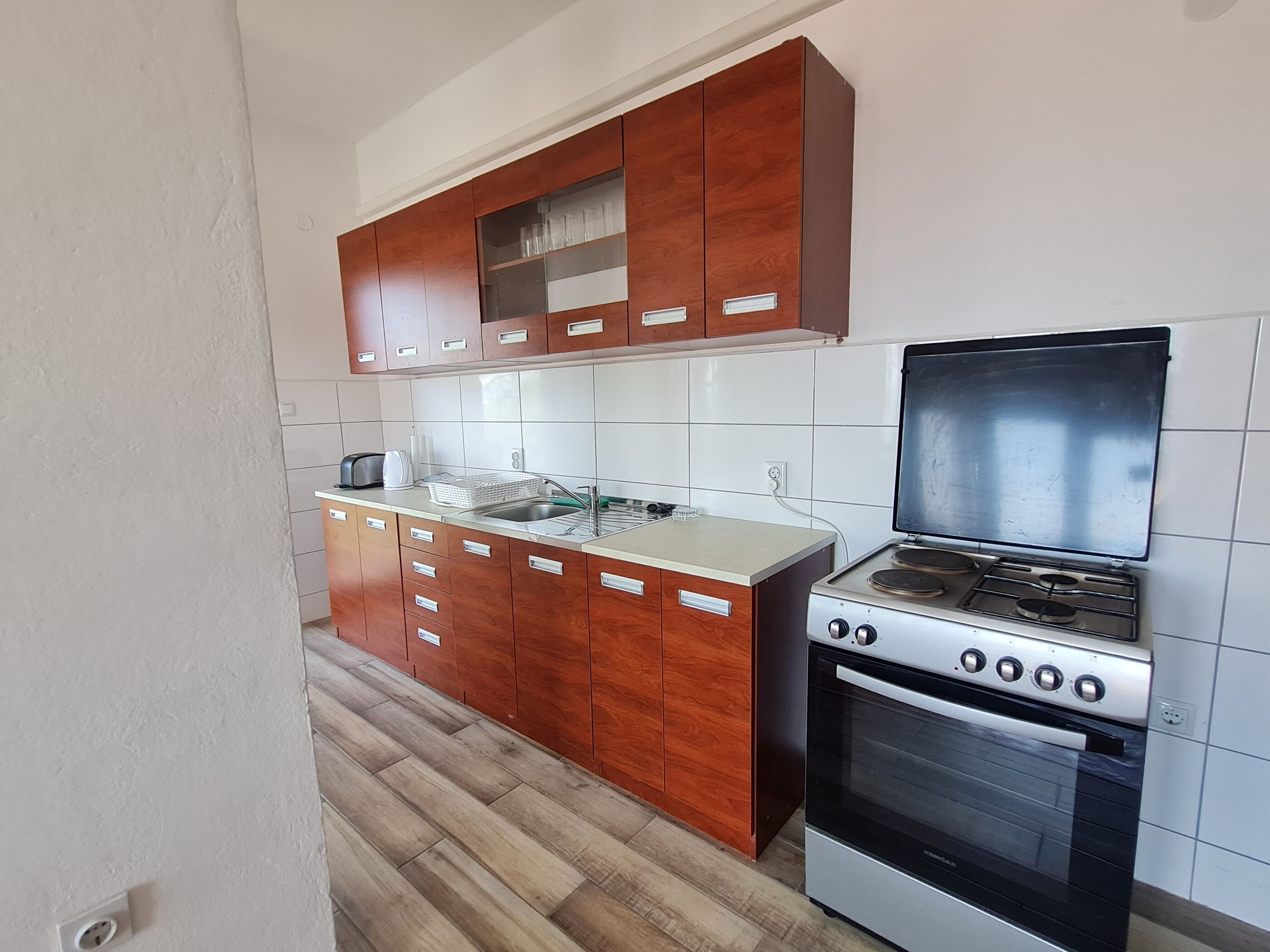 A kitchen with wooden cabinets, a stainless steel sink, and a gas stove.