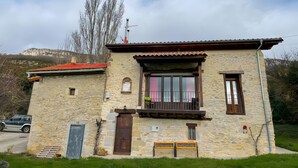 Un edificio de piedra con un balcón, una puerta y una ventana.