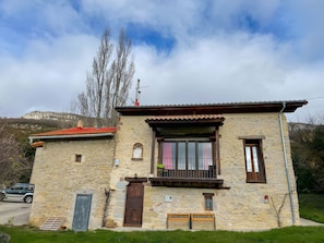 A stone building with a balcony, a door, and a window. - Berrobiaenea Country House: Nature and Sustainability (Narcué)
