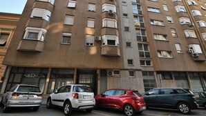 A multi-story building with several parked cars in front. - Apartment Corina (Rijeka)