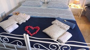 Un lit bien fait, avec une literie à motifs, une décoration en forme de cœur et des serviettes.