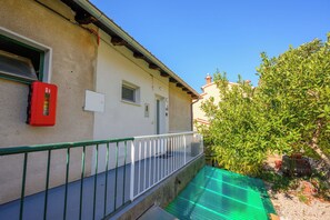 En bygning med balkon, brandslukker og markise.