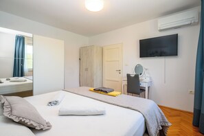Une chambre d’hôtel équipée d’un lit, d’un bureau, d’une chaise, d’une télévision et d’un appareil de climatisation.