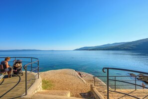 A coastal walkway with a clear view of the sea and distant hills. - Apartment Sea View (Labin)
