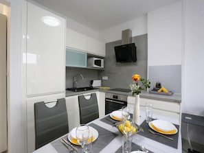 A modern kitchen with white cabinets, a microwave, and a built-in oven. - Apartment Sea View (Labin)