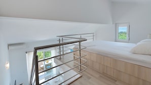 A modern bedroom with a bed, a window, and a balcony railing. - Apartments Marina (Novalja)