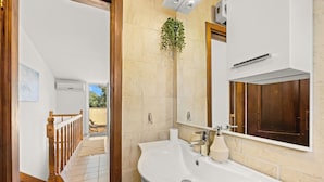 Une salle de bain avec un grand lavabo, un miroir et une porte en bois.
