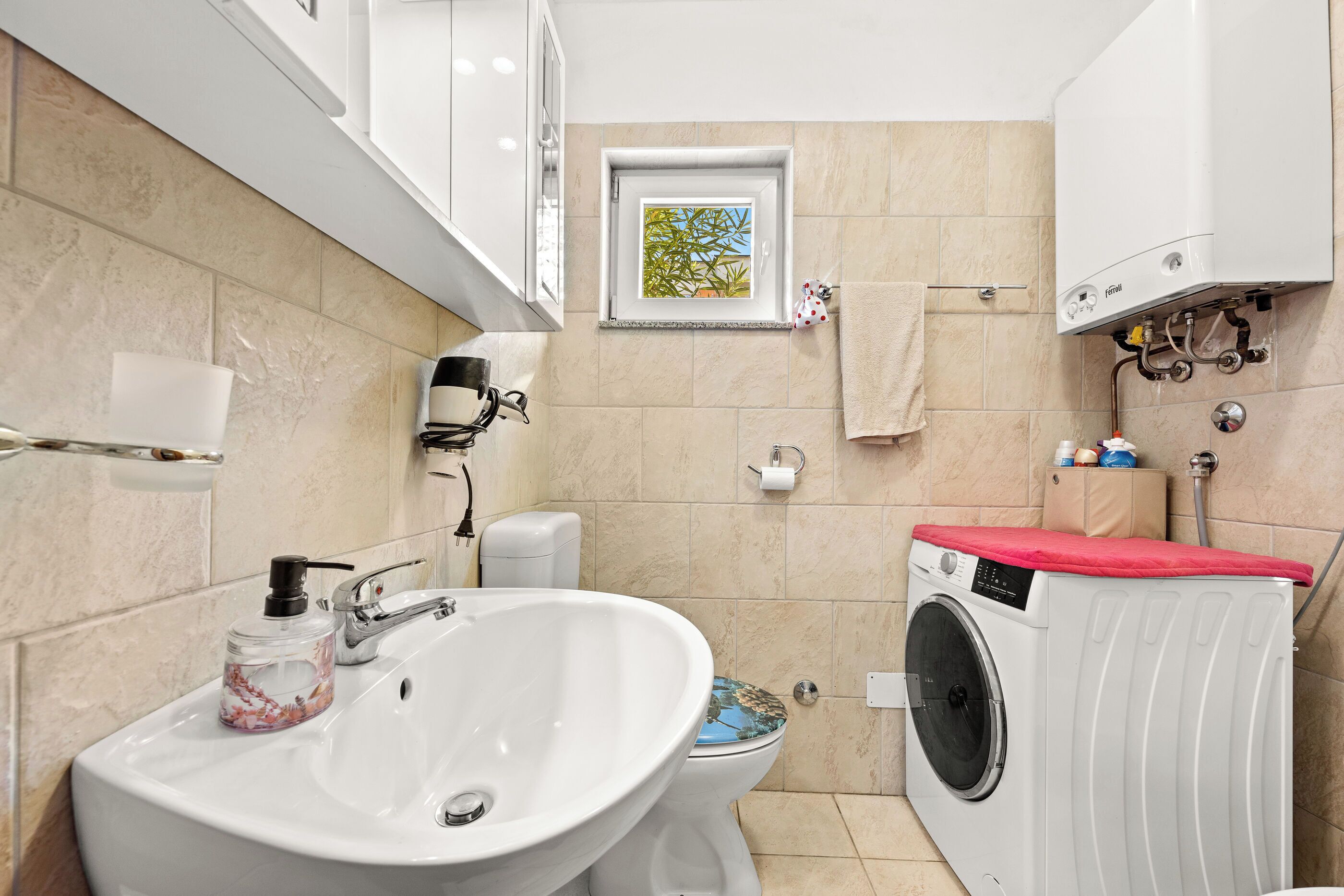 Ein Badezimmer mit Waschbecken, Toilette und Waschmaschine.