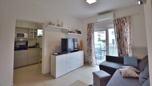 Ein modernes Apartment mit Küche, Wohnbereich und Balkon.