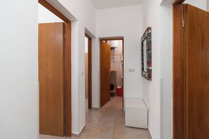 A hallway with wooden doors and a tiled floor. - Apartments Ivica (Vir)