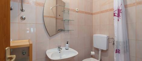 A bathroom with a white sink, toilet, and shower curtain.